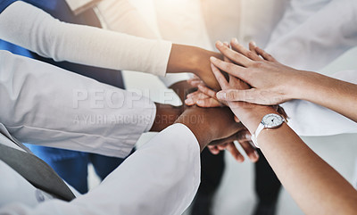 Buy stock photo Shot of a group of doctors joining their hands in solidarity at a hospital