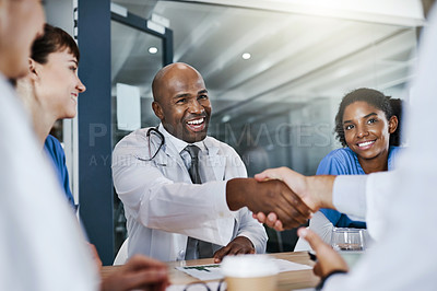 Buy stock photo Shot of doctors shaking hands during a meeting in a hospital