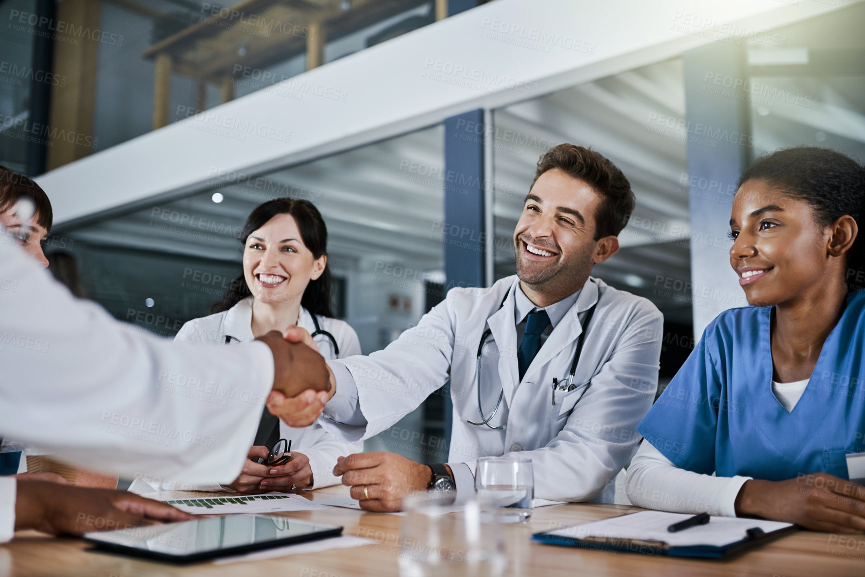 Buy stock photo Shot of doctors shaking hands during a meeting in a hospital