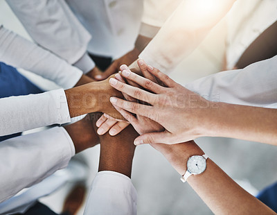 Buy stock photo Shot of a group of doctors joining their hands in solidarity at a hospital