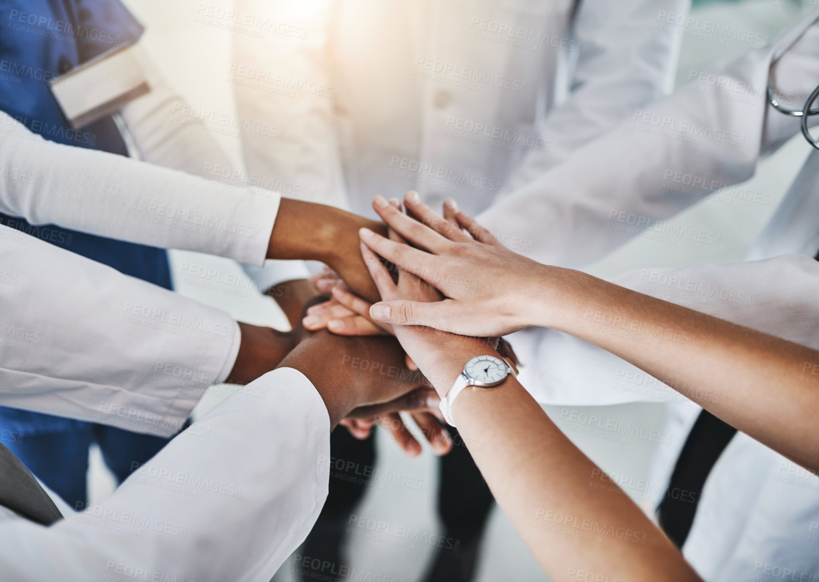 Buy stock photo Shot of a group of doctors joining their hands in solidarity at a hospital