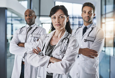 Buy stock photo Portrait of a team of confident doctors standing together in a hospital