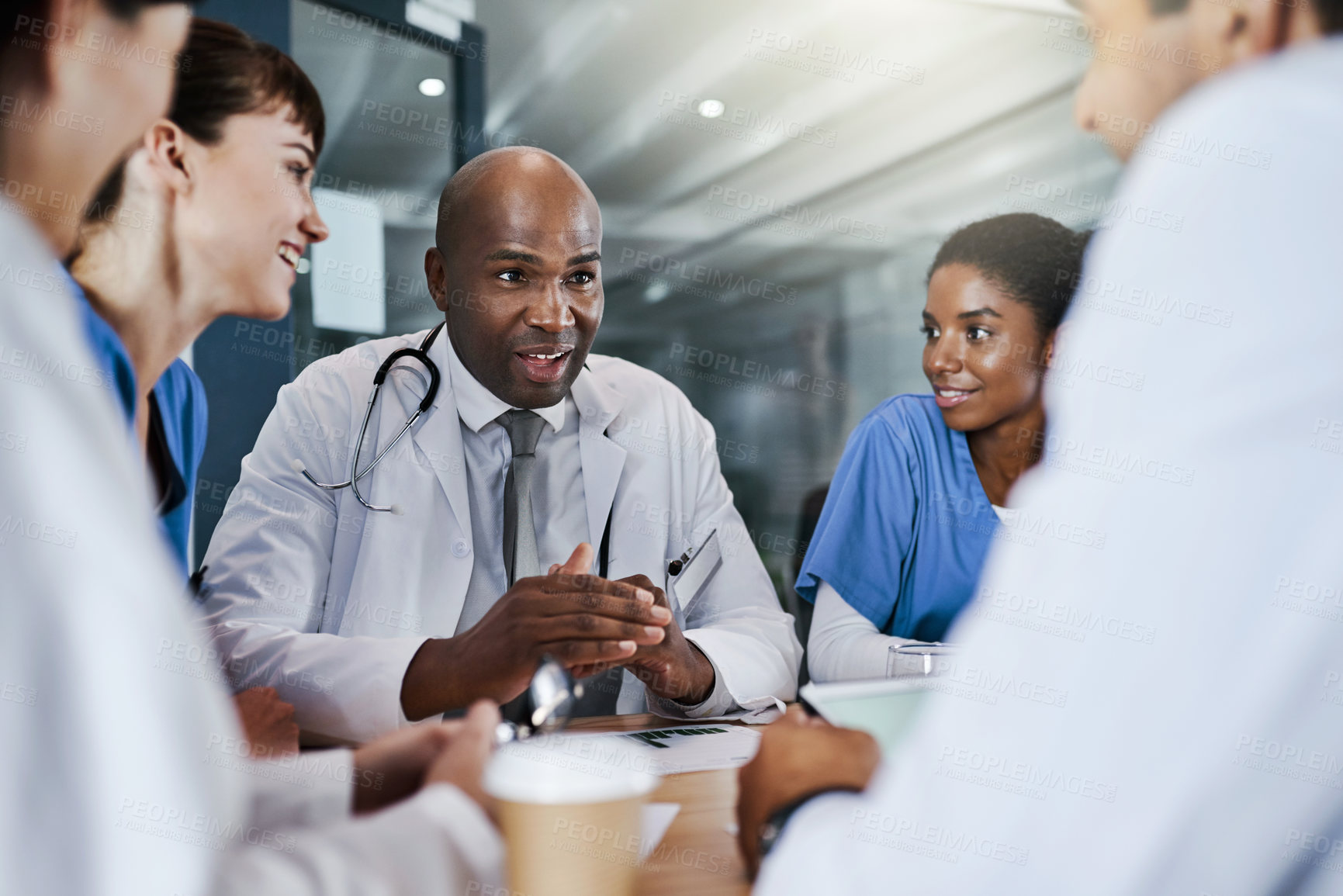 Buy stock photo Shot of a group of doctors having a meeting in a hospital