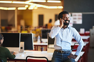 Buy stock photo Shot of a confident businessman talking on his cellphone while standing in an modern office