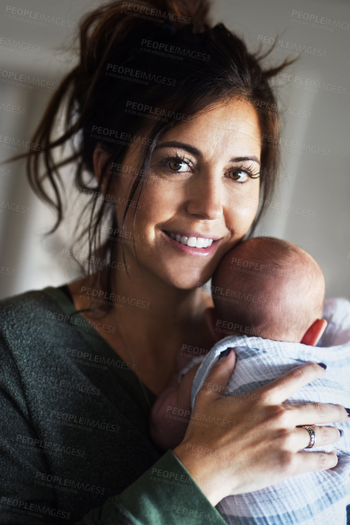 Buy stock photo Portrait of a cheerful young woman holding her little infant son at home during the day