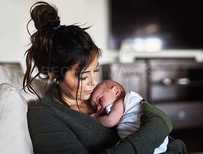 Buy stock photo Shot of a cheerful young woman holding her little infant son at home during the day