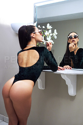 Buy stock photo Cropped shot of a sexy young woman applying lipgloss while looking in the mirror at home