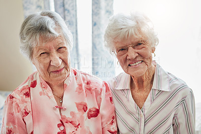 Buy stock photo Portrait of two happy elderly women spending time with each other at home