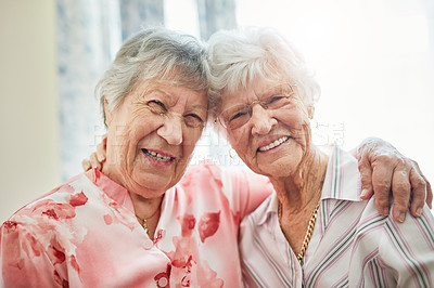 Buy stock photo Portrait of two happy elderly women embracing each other at home