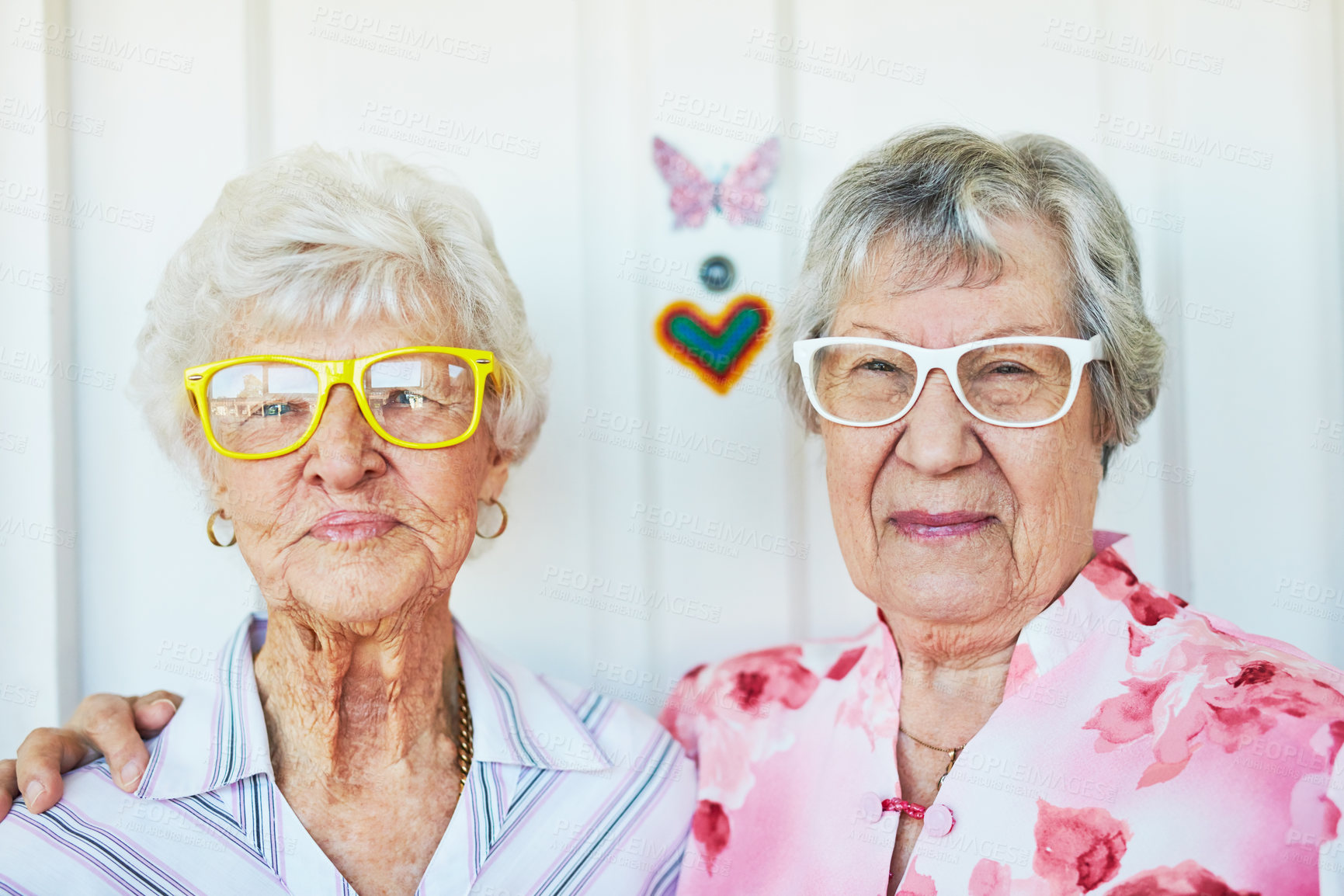 Buy stock photo Portrait of two happy elderly women wearing funky glasses at home