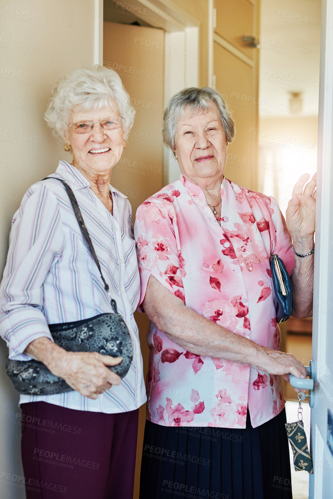Buy stock photo Portrait of two elderly woman closing the door before they leave to go out