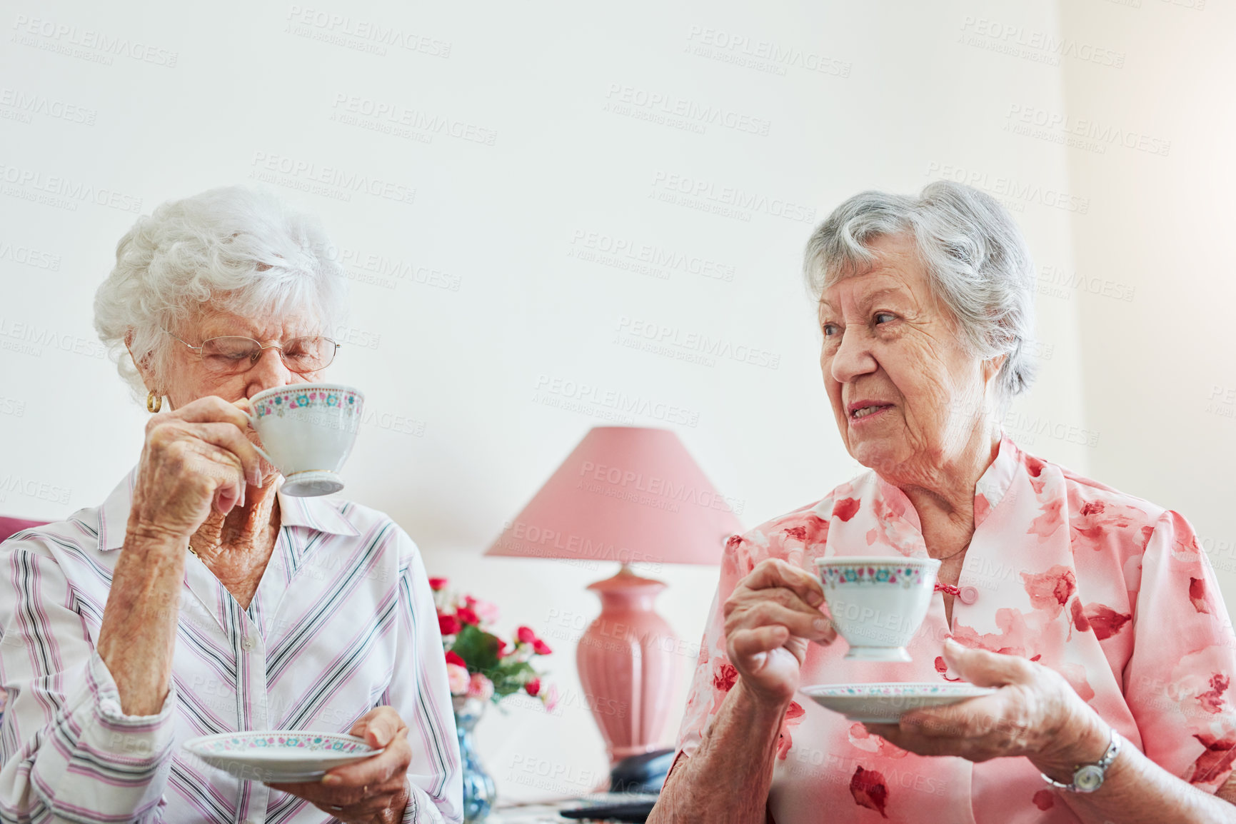 Buy stock photo Elderly women, friends and tea in lounge with smile in portrait for care, love or bonding with reunion. Senior people, listening and coffee for connection in morning, chat or together in nursing home