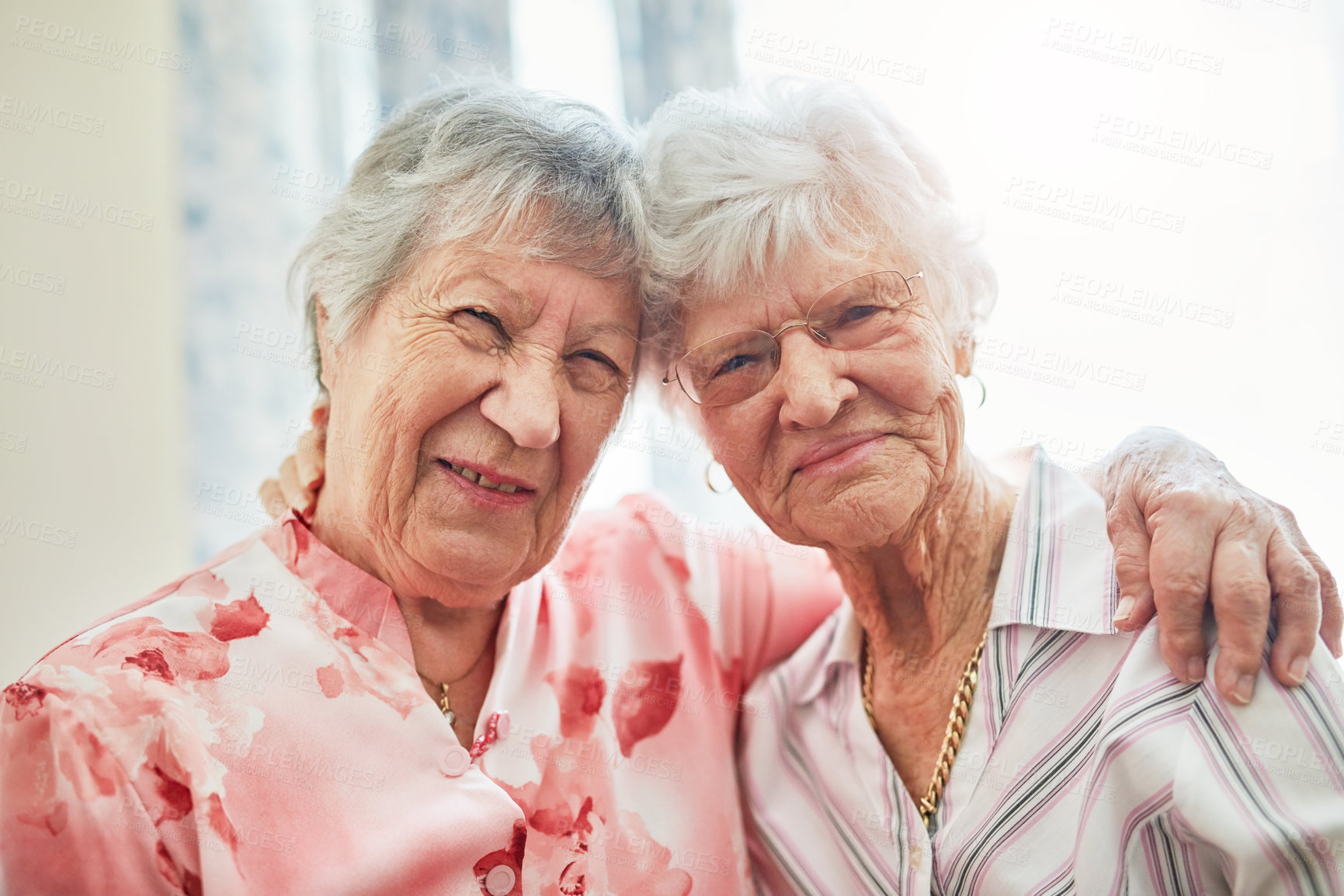 Buy stock photo Friends, senior women and joy in retirement home with hug or smile and fun. Pensioner, portrait and happy or confident in bonding to relax on break at old age house for wellbeing, wellness and health