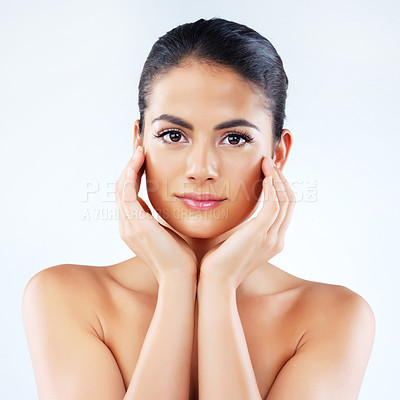 Buy stock photo Studio portrait of an attractive young woman feeling her skin against a gray background