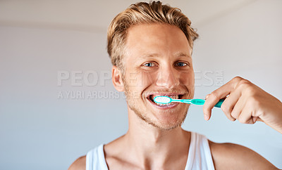 Buy stock photo Portrait of a young man brushing his teeth at home