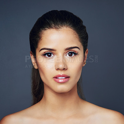 Buy stock photo Studio shot of a beautiful young woman with flawless skin posing against blue background