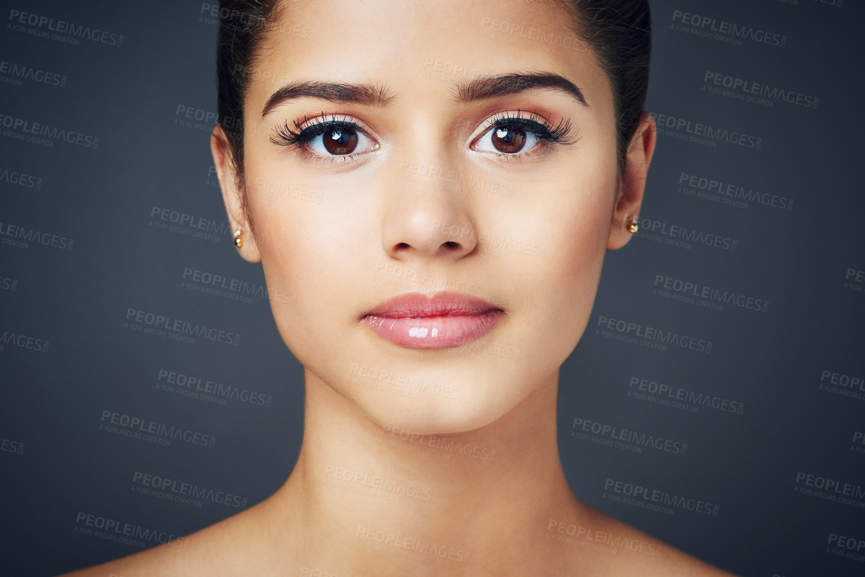 Buy stock photo Studio shot of a beautiful young woman with flawless skin posing against a blue background