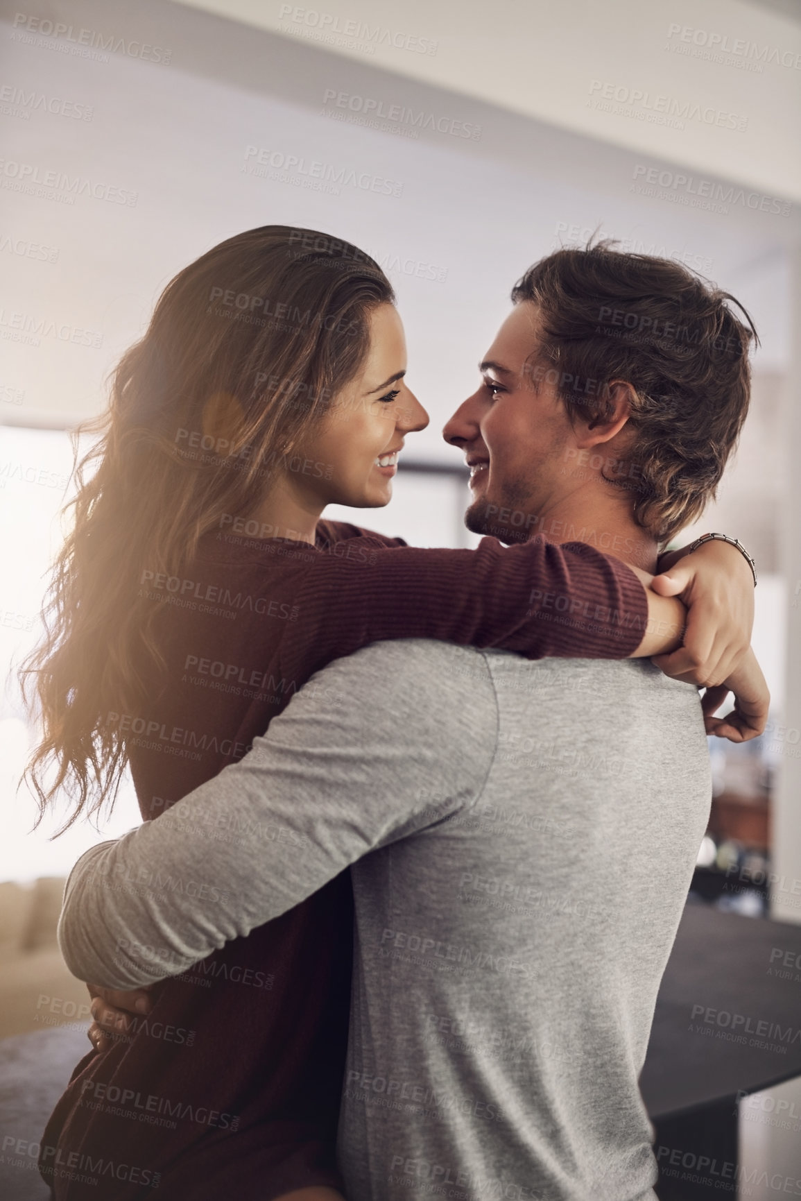 Buy stock photo Woman, man and hug for love, care and quality time together with commitment to relationship at home. Happy young couple, hugging and romance of lovers, smile and relax with trust of partner in house