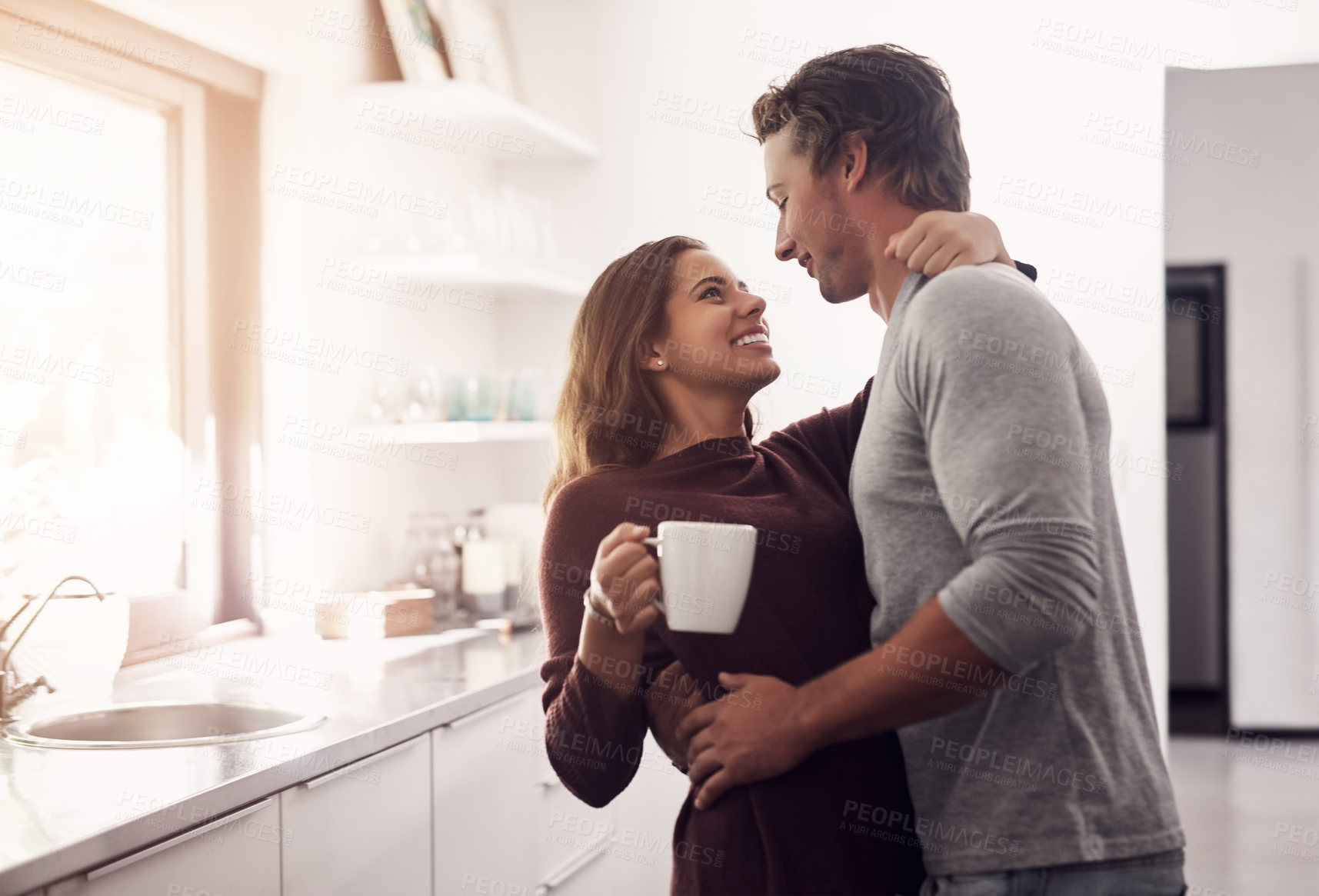 Buy stock photo Shot of an affectionate young couple having a coffee break at home