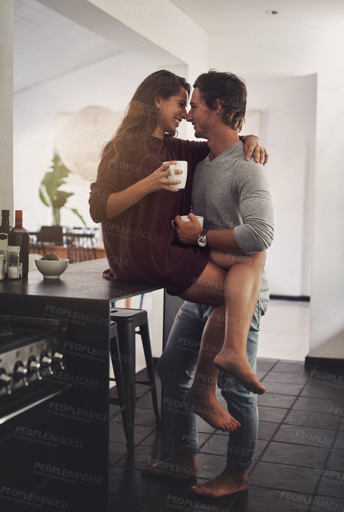 Buy stock photo Shot of an affectionate young couple having a coffee break at home