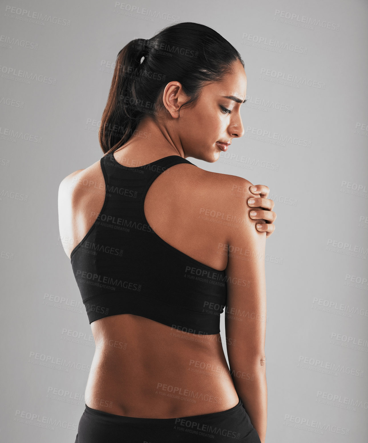 Buy stock photo Rearview shot of a young woman suffering from back pain