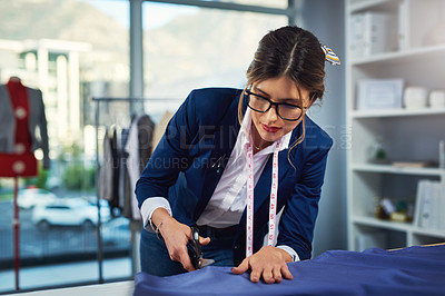 Buy stock photo Cropped shot of an attractive young fashion designer cutting fabric in her design workshop