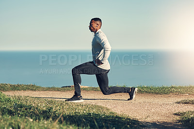 Buy stock photo Full length shot of a handsome young man stretching before exercising outdoors