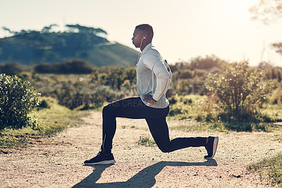 Buy stock photo Fitness, stretching and black man in mountain with headphones, health and wellness for outdoor run. Muscle workout, warm up and athlete in nature with music streaming, earphones and exercise on path.
