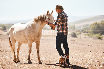 Buy stock photo Shot of a farmer standing with a horse on a ranch