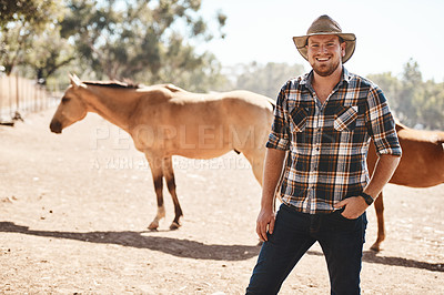 Buy stock photo Portrait of a farmer standing on a ranch with horses in the background