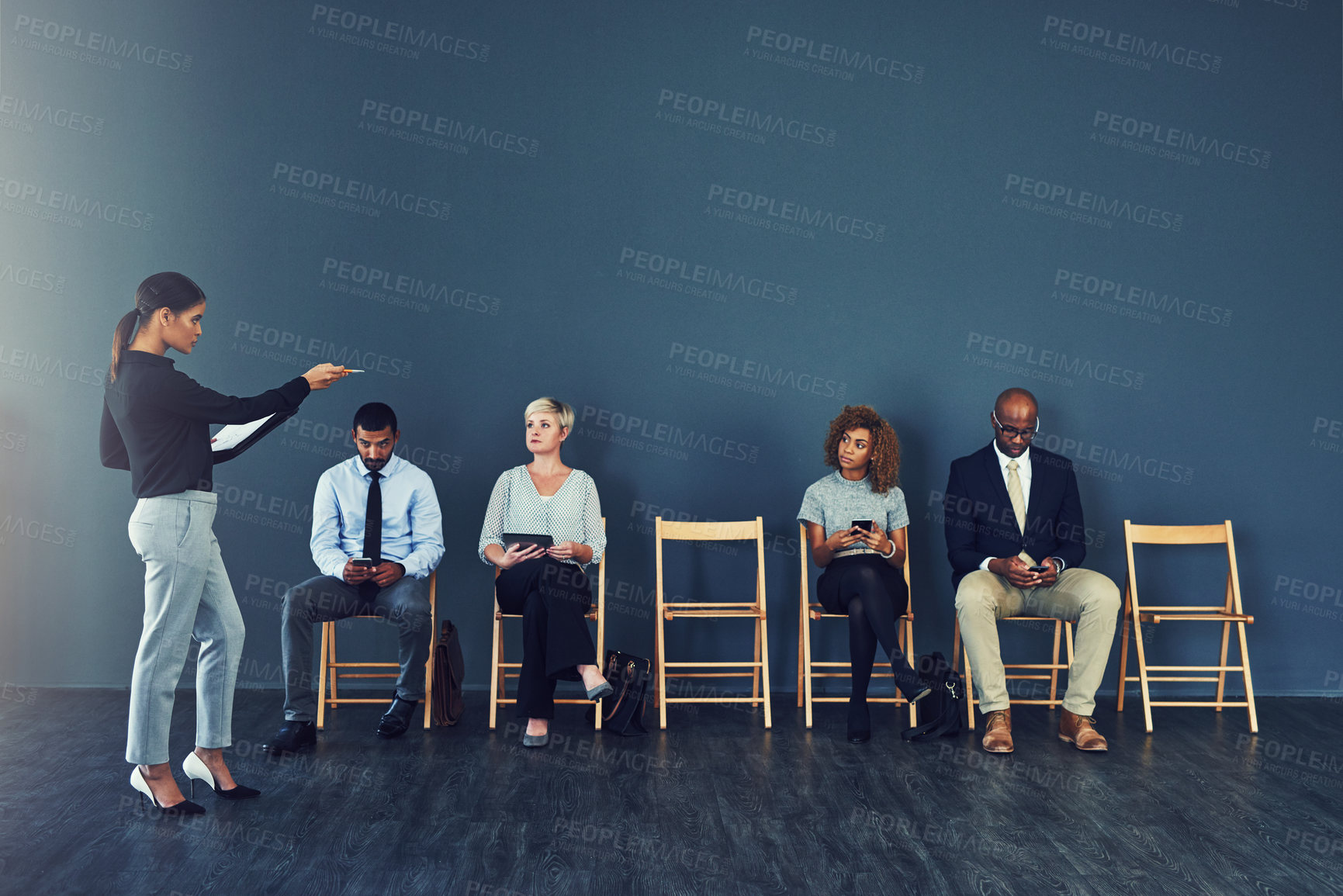 Buy stock photo Shot of a woman pointing at one of the candidates waiting to be interviewed