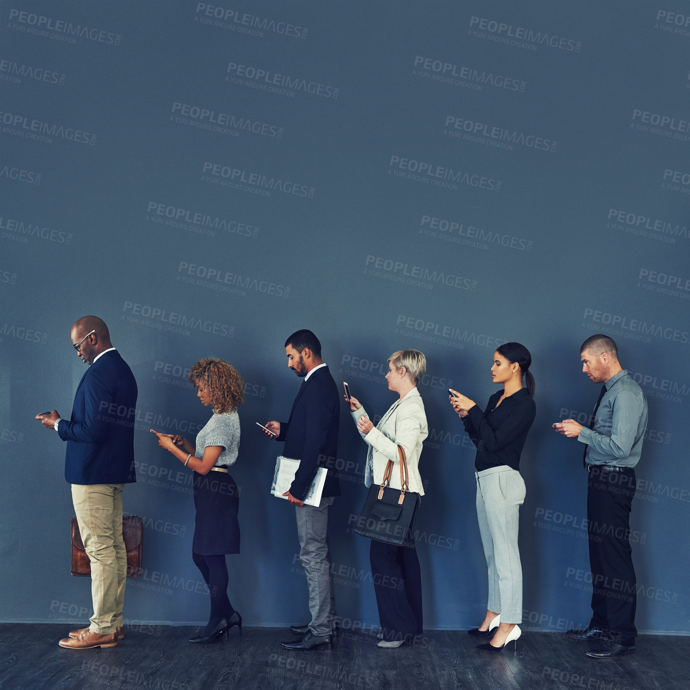 Buy stock photo Studio shot of a group of businesspeople using wireless devices while waiting in line