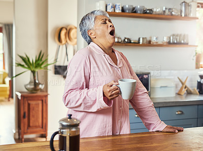 Buy stock photo Shot of a frightful looking elderly woman yelling out in pain and discomfort while drinking coffee in the kitchen