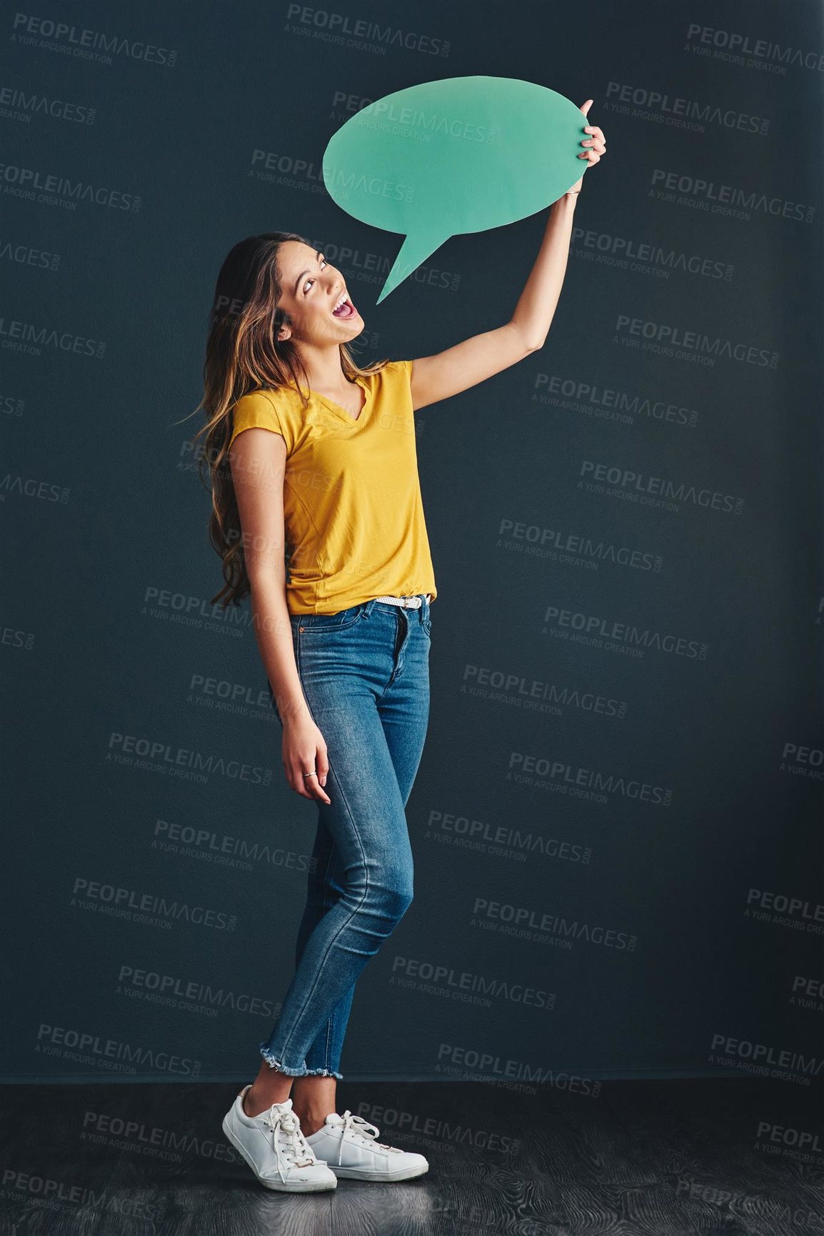 Buy stock photo Studio shot of a beautiful young woman holding a speech bubble
