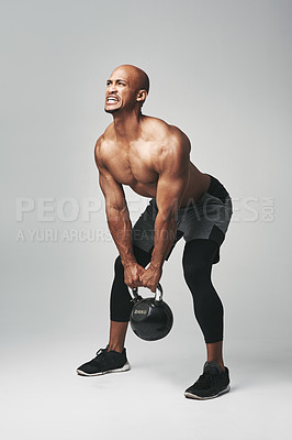 Buy stock photo Black man, heavy and kettle bell in studio, struggle and progress for workout or training. Male person, athlete and commitment to weightlifting on gray background, tough and dumbbell challenge
