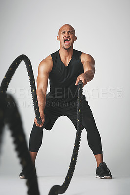 Buy stock photo Battle rope, fitness and man in studio for intense training, exercise and bodybuilder workout. Sports, white background and isolated person with gym equipment for wellness, muscle and performance