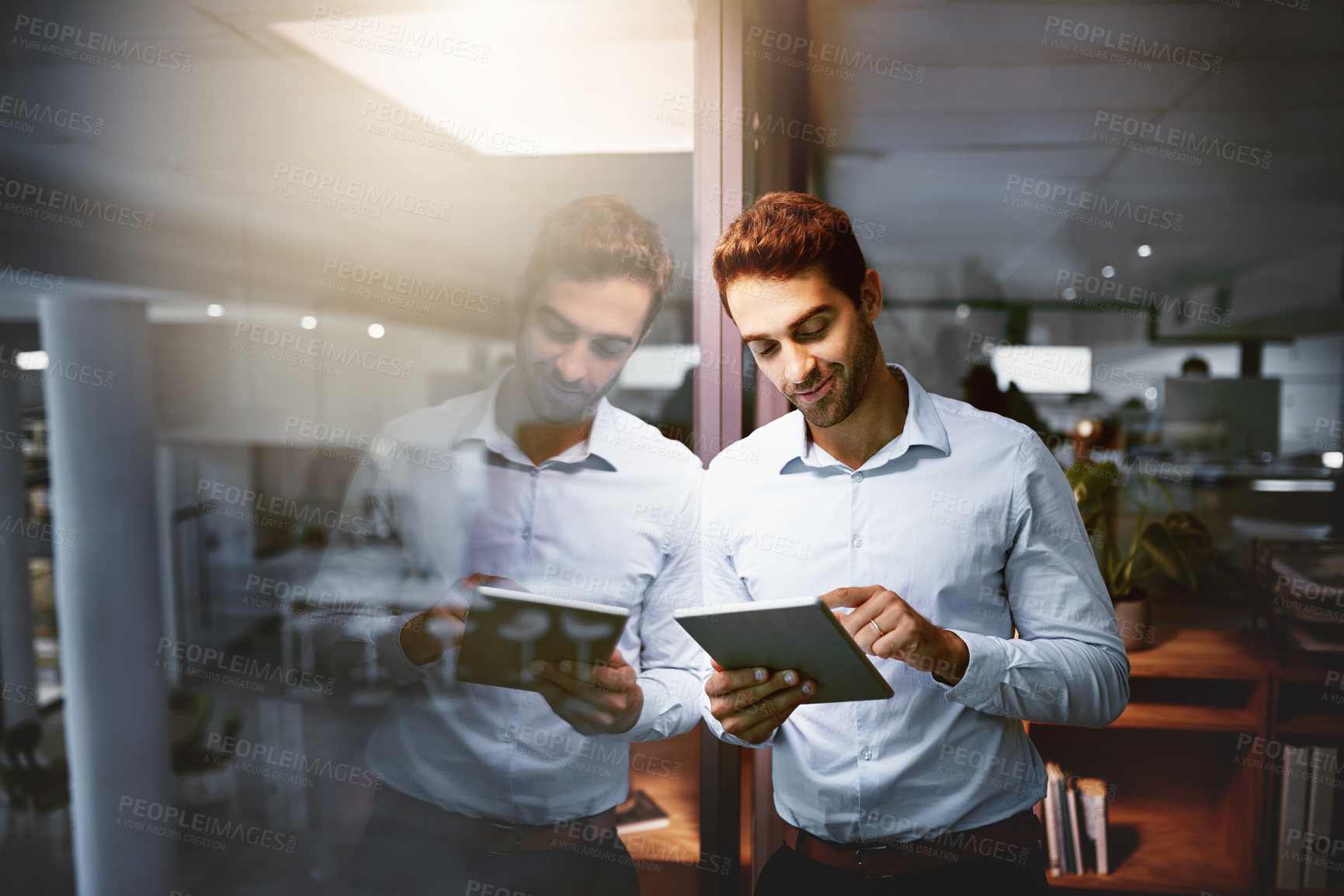 Buy stock photo Office, smile and businessman at night with tablet, research information and planning for article. Glass reflection, male person and journalist with digital for new story, online report and deadline