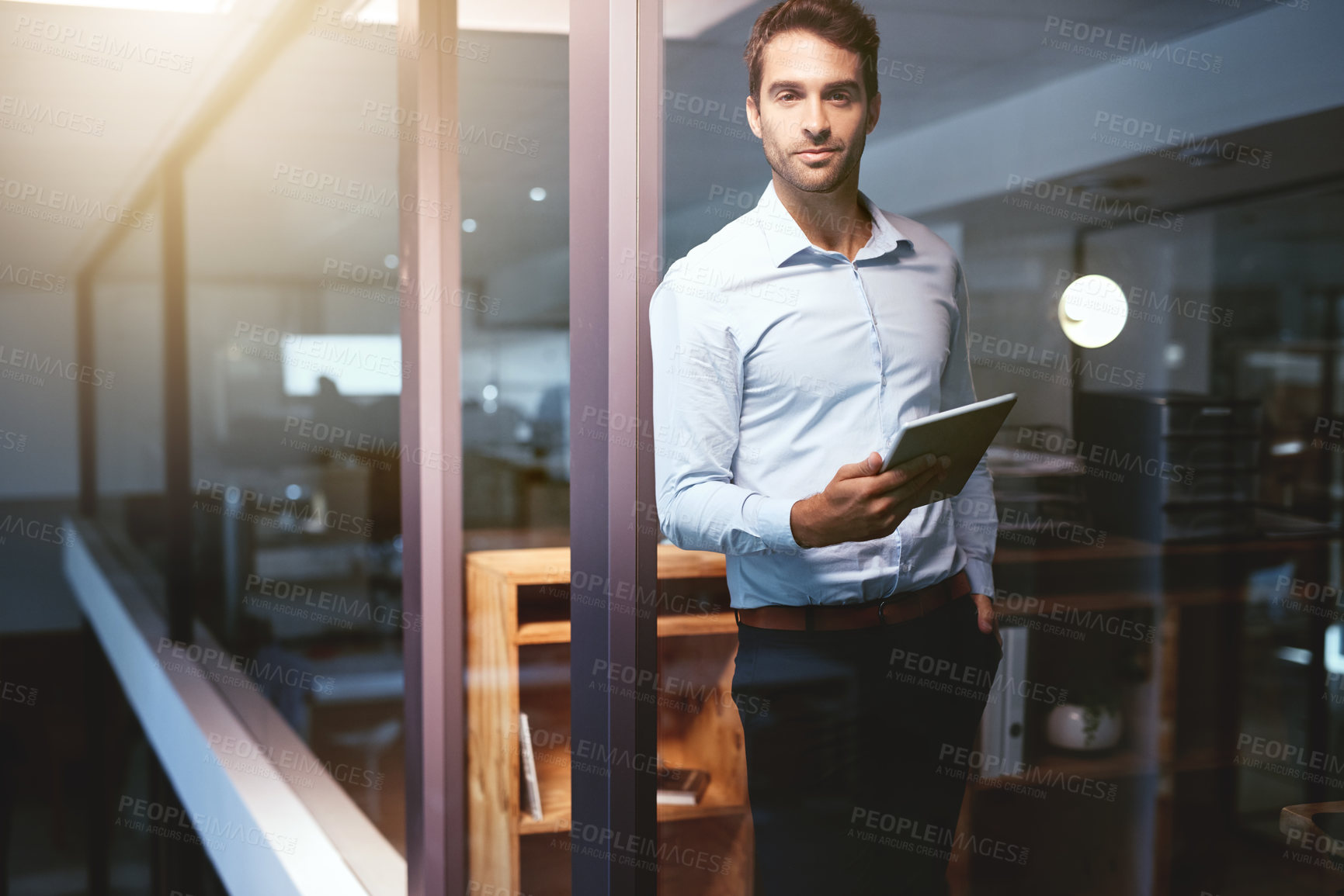 Buy stock photo Portrait of a young businessman working late on a digital tablet in an office