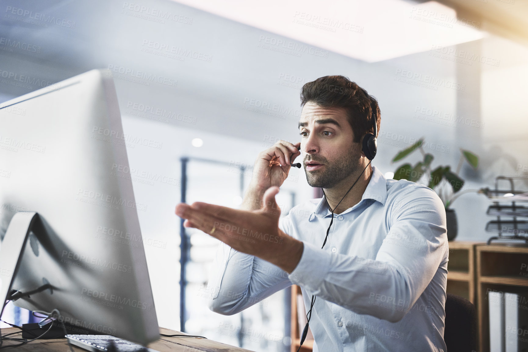 Buy stock photo Shot of a young call centre agent looking upset while working late in an office