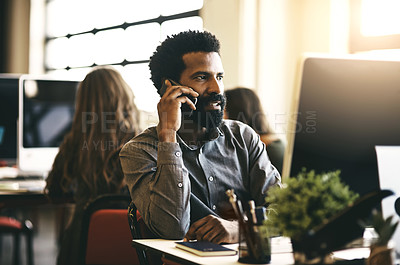 Buy stock photo Shot of a businessman talking on his phone while sitting at his desk