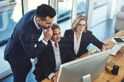 Buy stock photo Shot of a group of businesspeople working together on a computer in an office