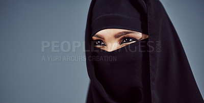 Buy stock photo Studio shot of a young arabic woman wearing a burka against a gray background