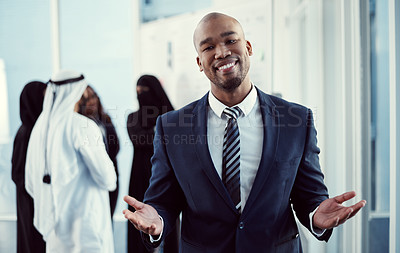 Buy stock photo Cropped portrait of a handsome young businessman standing in the office with his colleagues in the background