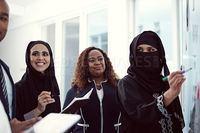 Buy stock photo Cropped shot of a group of diverse business colleagues working together on a whiteboard in their office