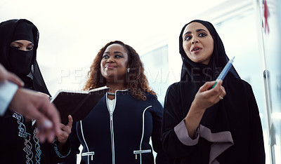 Buy stock photo Low angle shot of a group of diverse business colleagues working together on a whiteboard in their office