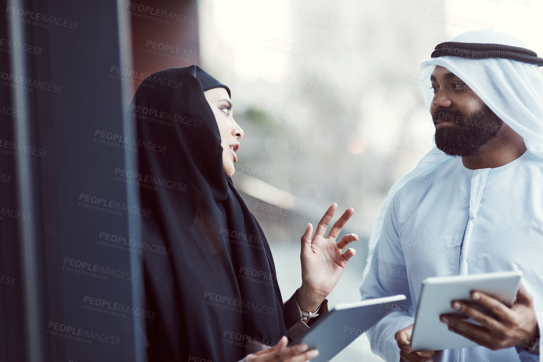 Buy stock photo Cropped shot of two arabic business colleagues working together outside on their office balcony