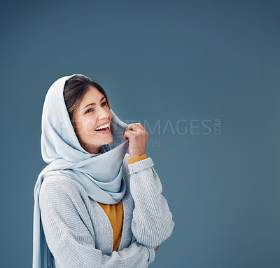 Buy stock photo Thinking, fashion and happy muslim woman with dream in studio isolated on a blue background mockup space. Hijab, smile and person with idea in stylish casual clothes for vision, decision or laughing
