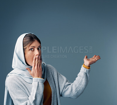 Buy stock photo Cropped portrait of an attractive young woman endorsing your product while standing against a grey background