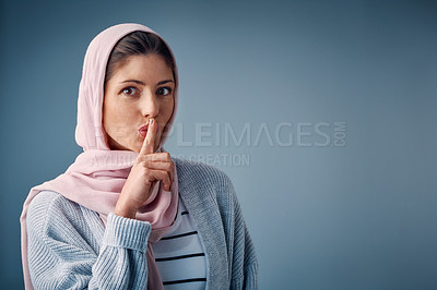 Buy stock photo Portrait, space and shush with muslim woman in studio on gray background for advertising or marketing secret. Emoji, islamic or finger on lips and private young person with hand gesture for whisper