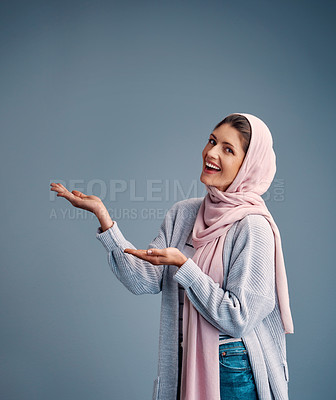 Buy stock photo Cropped portrait of an attractive young woman endorsing your product while standing against a grey background